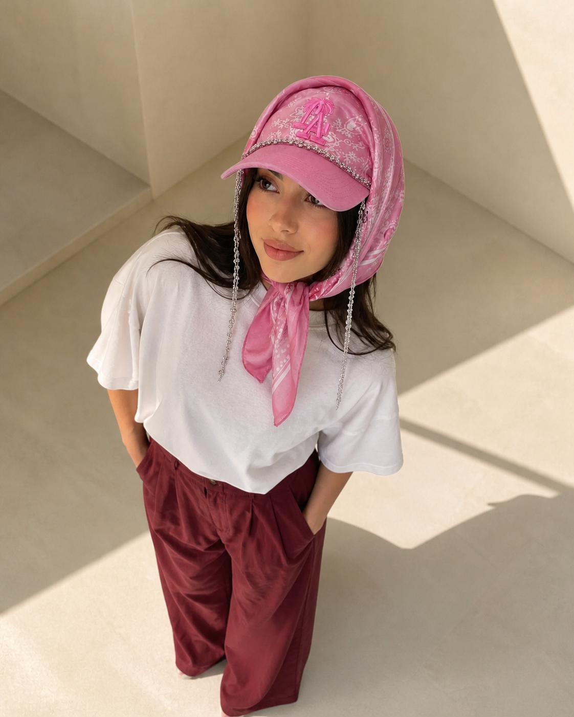 Pink Pop Scarf Cap photographed from above with burgundy pants
