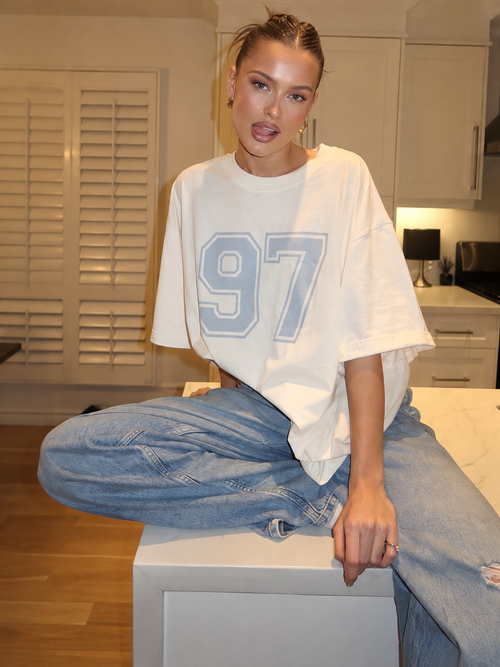 White 97 oversized graphic tee styled with jeans