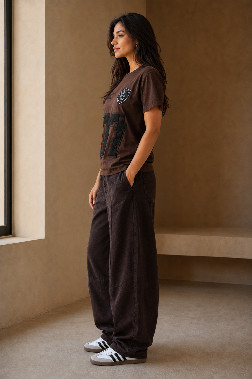 Queenly Varsity 07 brown graphic tee side view with dark brown barrel pants