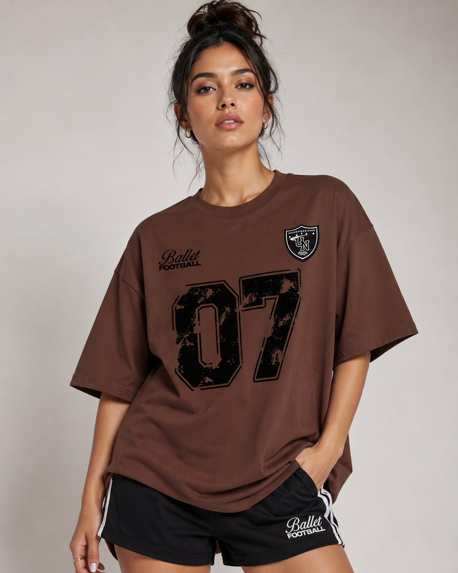 Woman wearing the Queenly Varsity 07 oversized brown graphic T-shirt